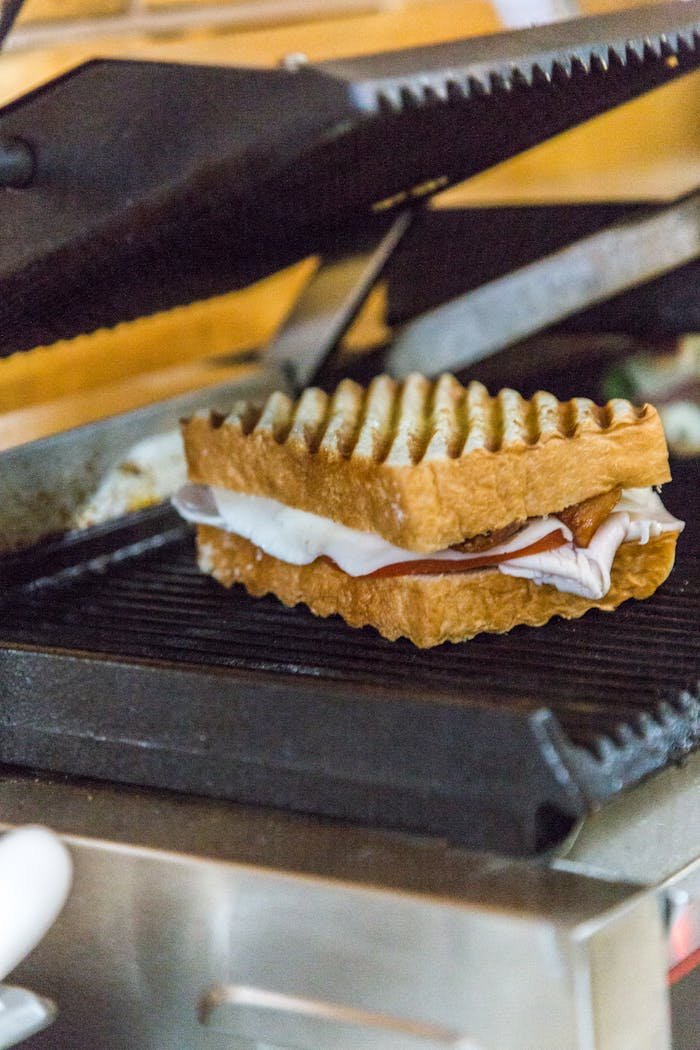 A delicious grilled cheese sandwich being cooked on a panini press.