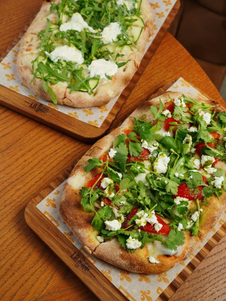 pexels photo 21753117 21753117 Delicious Italian flatbreads with fresh arugula and ricotta on wooden boards.