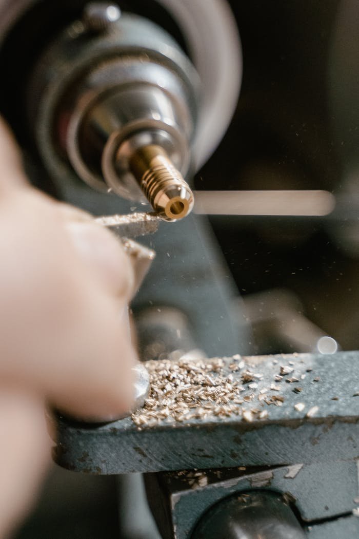 Detailed close-up of a craftsman using a lathe for precision metalworking.